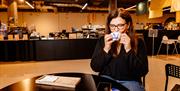 An image of a woman sipping from a mug in a Mediterranean/Arabic coffee shop.