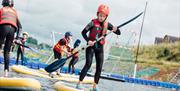 Image shows children playing on paddle boards