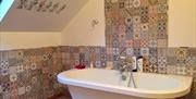 Tiled bathroom with a large bath.