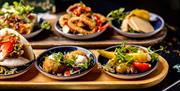A selection of small dishes on wooden boards.