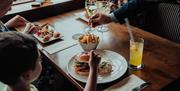 A family enjoying dinner and being served wine.