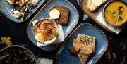 A selection of blue plates with different dishes seen from above.