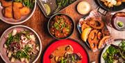 An above view of a table filled with tapas dishes.