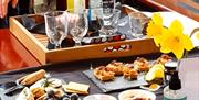 bottles of gin and a selection of cheeses sit on a table