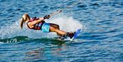 Image is of a female water-skier on the water