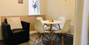 A dining room with a chair and a table and chairs.