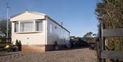 Image of the exterior of a static caravan and a stoned driveway