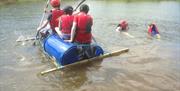 children ride a raft built from barrels.