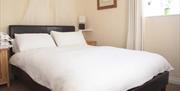 A double bed with white linen