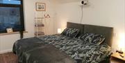 bedroom with 2 single beds, bedside lamps and clothing storage