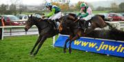 Image is of 2 horses and jockeys in mid race