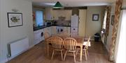 Image shows kitchen area with dining table and 6 chairs