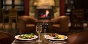 Table set for two with meals and glasses of wine