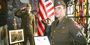 A man dressed up in a uniform from the Second World War standing in the gallery of the Northern Ireland War Memorial.