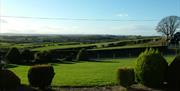 Image shows lawn in front of property with view of the countryside beyond