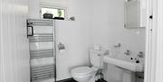 White bathroom with sink and toilet visible in image