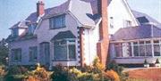 Exterior view of the front of a lodge with a conservatory.