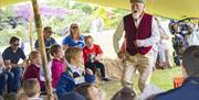 A storyteller is talking to children on the grounds of Hillsborough Castle and Gardens