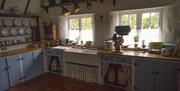 kitchen area with red tiled floor and 2 windows