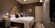 Image shows double bedroom with side tables and lamps