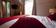 Double bedroom with bed, ensuite, TV and bedside lamp