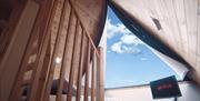 view of sky from open roof at bed in glamping pod