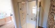 Image shows en-suite shower room with door open to bedroom.