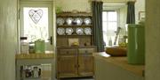 A kitchen with two windows and a large cupboard.