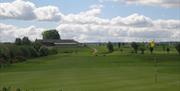 Image is of golf course with club house in the background