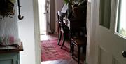 Image shows hallway into room with table and chairs