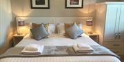 One of the apartments bedrooms with a Double bed, bedside tables and a wardrobe.