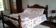 double wooden bed with red and white linen