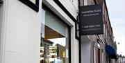 Image shows signage of Day Spa at front of property, its is dark grey with the text in white writing
