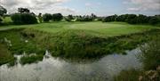Image is of golf course with lake in the foreground
