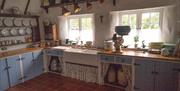 kitchen with red tiled floor and 2 windows