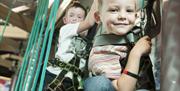 Image is a close up of 2 boys on a climbing frame