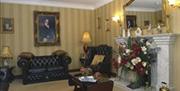 Carpeted sitting area with a leather suite, fireplace and a large mirror