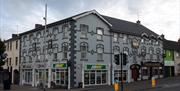 A grey building with subway on the bottom floor