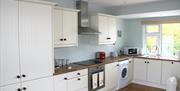The cottage has an open plan kitchen and dining hall area leading into a cosy sitting room with gas fire.
