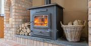 A woodburning fireplace with logs ready to heat the house.