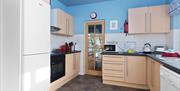 Kitchen with a fridge, cooker/oven, dishwasher, and various other kitchen accoutrements.