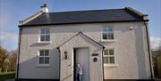 A boy at the door of Shamrock Cottage, near Kesh.