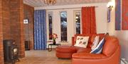 Large lounge area with a large red sofa and a fireplace.