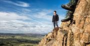 A hiker standing on the edge of Slemish