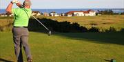 Gilfer teeing off on the green