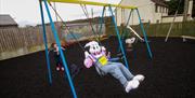 A bunny costume and a little girl playing in the park.