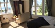 Bedroom with seating area and views out to the beach