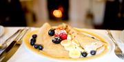 Pancakes with blueberries, bananas and strawberries.