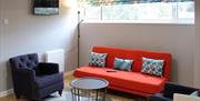 living area with orange sofa and 2 navy armchairs