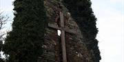 Ruins of old Church with wooden Cross in the centre.